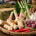 Lengkuas segar di tampah bambu bersama tempe dan bumbu dapur tradisional