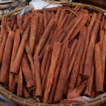 Kumpulan batang kayu manis berkualitas tinggi dalam nampan bambu di pasar rempah tradisional