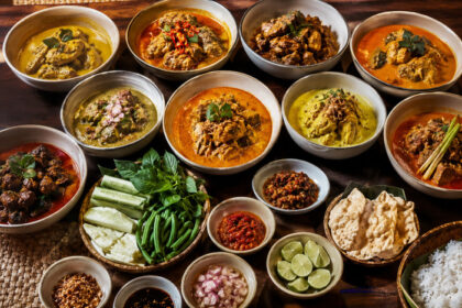 Sajian macam-macam gulai khas Indonesia lengkap dengan nasi putih, sambal, lalapan, kerupuk, dan aneka kondimen di atas meja makan.