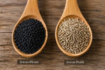 Perbedaan biji jintan hitam (Nigella sativa) dan jintan putih (Cuminum cyminum) pada dua sendok kayu sebagai ilustrasi rempah dapur.