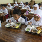 Anak sekolah menikmati makanan bergizi gratis MBG di dalam kelas