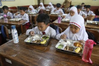 Anak sekolah menikmati makanan bergizi gratis MBG di dalam kelas
