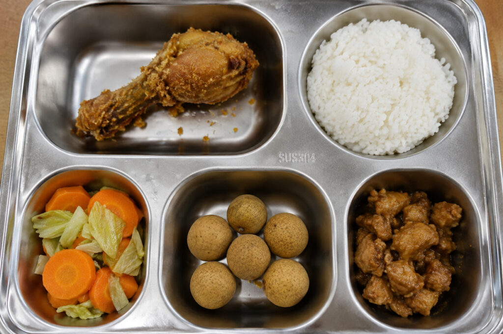 Menu MBG berisi nasi, ayam goreng, sayuran, buah, dan lauk