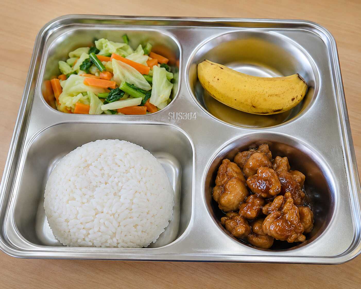 Menu MBG murah berupa nasi putih, ayam kecap, tumis sayuran wortel dan kol, serta pisang dalam wadah ompreng stainless steel